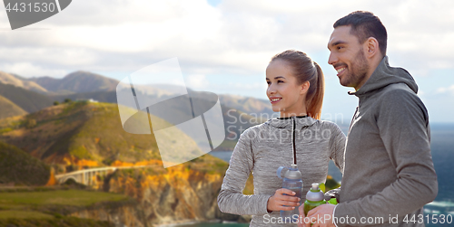 Image of couple of sportsmen with water over big sur coast