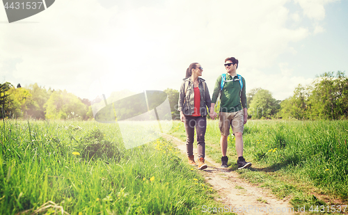 Image of happy couple with backpacks hiking outdoors