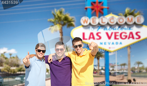 Image of group of male friends hugging over las vegas sign