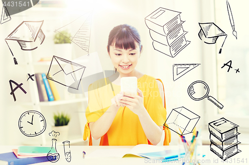 Image of happy young woman student with smartphone at home