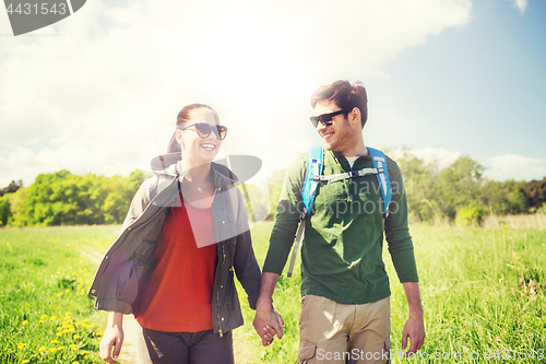 Image of happy couple with backpacks hiking outdoors