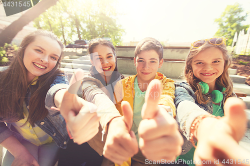 Image of teenage friends or students showing thumbs up