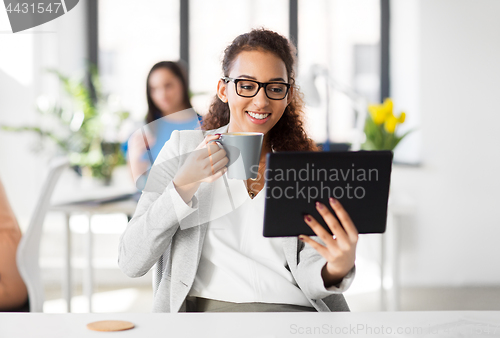 Image of businesswoman with tablet pc and coffee at office
