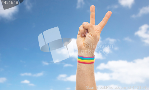Image of hand with gay pride rainbow wristband make peace
