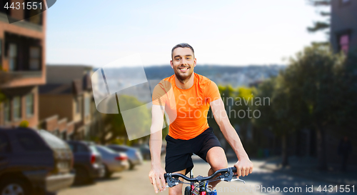 Image of happy man riding bicycle over san francisco city