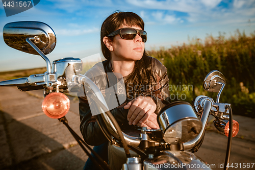 Image of Biker girl sitting on motorcycle