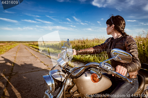 Image of Biker girl sitting on motorcycle