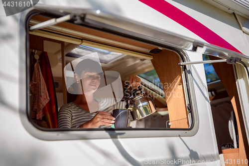 Image of Woman cooking in camper, motorhome interior