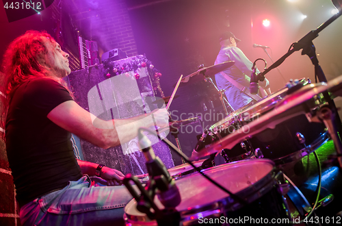 Image of Drummer playing on drum set on stage.