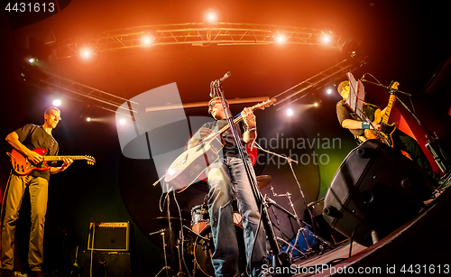 Image of Band performs on stage in a nightclub