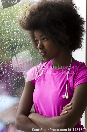 Image of portrait of young afro american woman in gym while listening mus