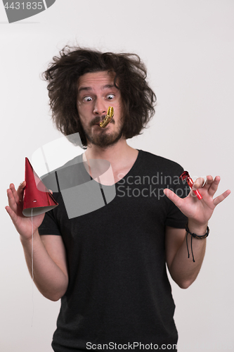 Image of Portrait of a man in party hat blowing in whistle