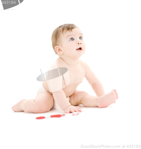 Image of baby boy in diaper with toothbrush