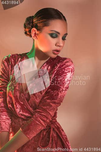 Image of High Fashion model woman in colorful bright lights posing in studio,