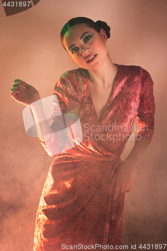 Image of High Fashion model woman in colorful bright lights posing in studio,
