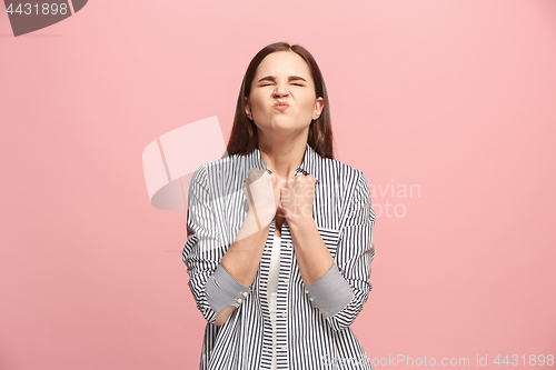 Image of Portrait of an angry woman looking at camera isolated on a pink background