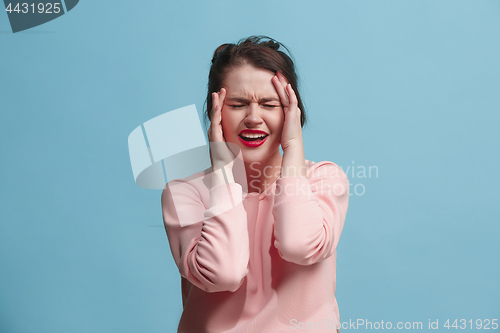 Image of Woman having headache. Isolated over blue background.