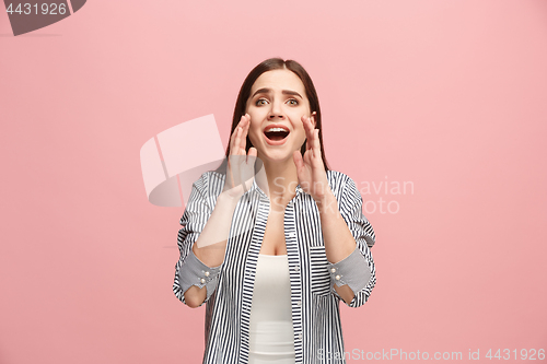 Image of The young emotional angry woman screaming on pink studio background