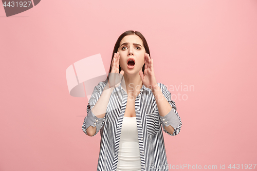 Image of The young emotional angry woman screaming on pink studio background