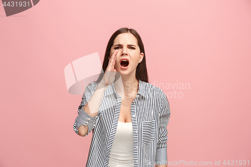 Image of The young emotional angry woman screaming on pink studio background