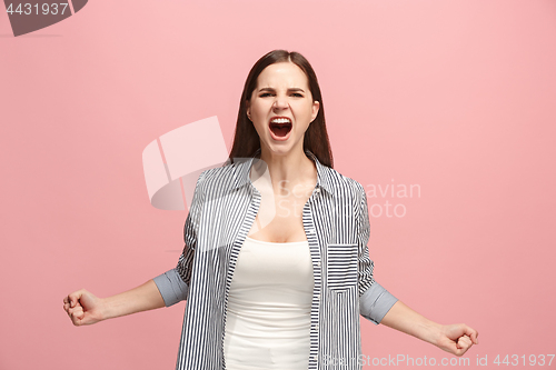 Image of The young emotional angry woman screaming on pink studio background