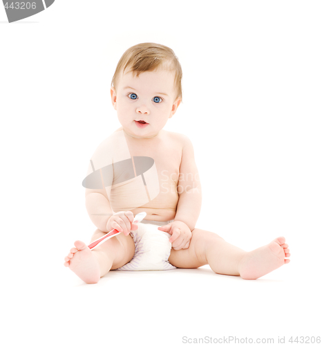 Image of baby boy in diaper with toothbrush