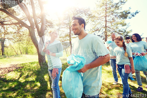 Image of volunteers with garbage bags walking outdoors