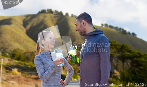 Image of couple of sportsmen with water over big sur hills