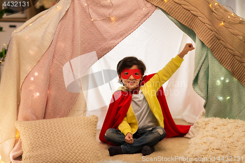 Image of happy boy in super hero stuff in kids tent at home