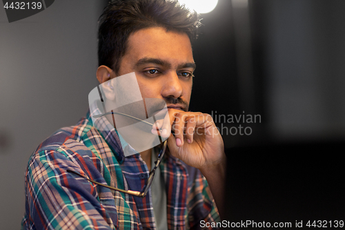 Image of close up of creative man working at night office