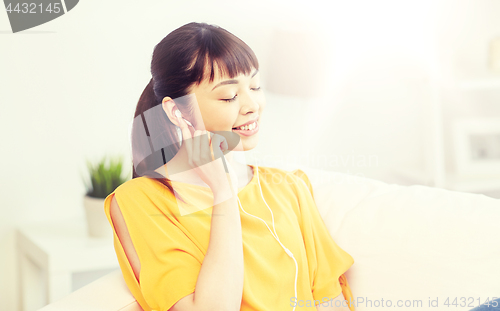 Image of happy asian woman with earphones listening music