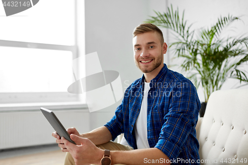 Image of happy smiling man with tablet pc at office