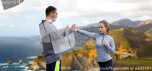 Image of happy woman with coach working on strike outdoors