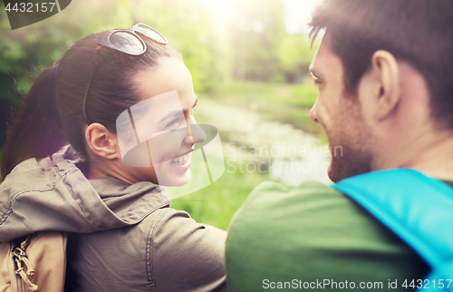 Image of smiling couple with backpacks in nature