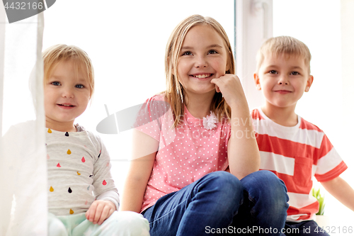 Image of happy little kids having fun at window