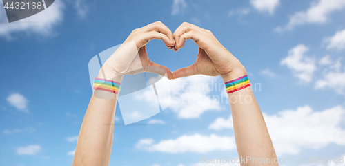 Image of male hands with gay pride wristbands showing heart