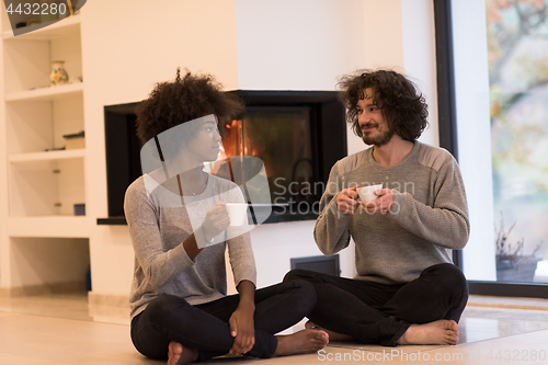Image of multiethnic couple  in front of fireplace