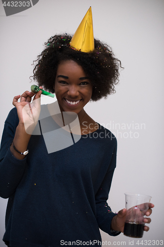 Image of black woman in party hat blowing in whistle