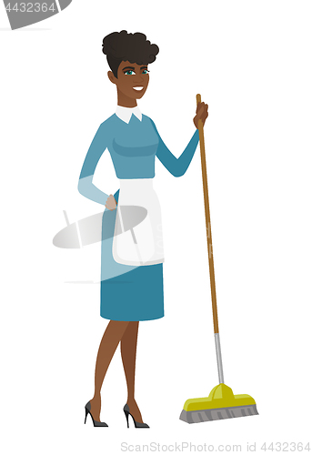 Image of Young housemaid sweeping floor with a broom.