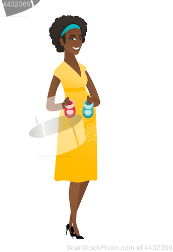 Image of African pregnant woman holding baby booties.