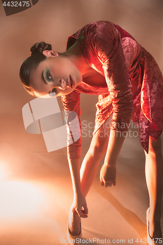 Image of High Fashion model woman in colorful bright lights posing in studio,