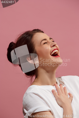 Image of The happy business woman standing and smiling against pink background.