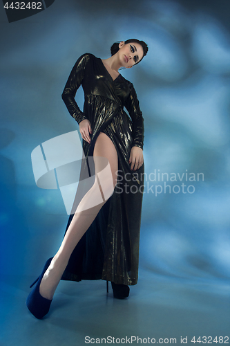 Image of Fashion young woman in black stilish dress. Glamour sexy model in fashion pose, stylish make-up, fashion heels.