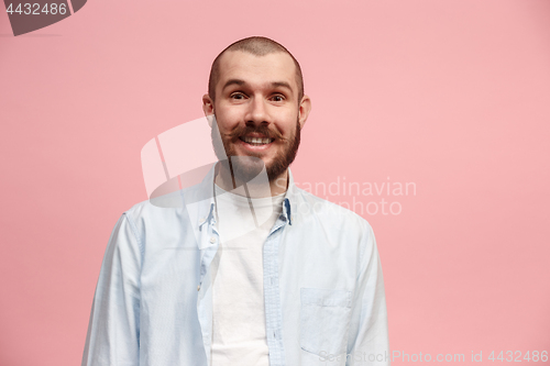 Image of The happy business man standing and smiling against pink background.