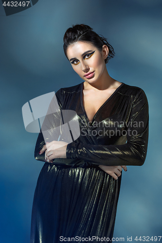 Image of Fashion young woman in black stilish dress. Glamour sexy model in fashion pose, stylish make-up, fashion heels.