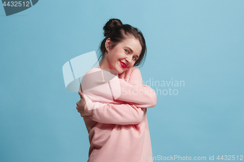 Image of The happy business woman standing and smiling against pastel background.