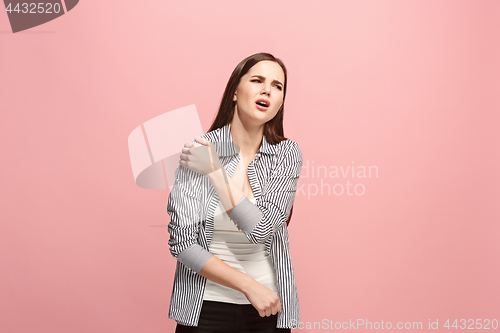 Image of The shoulder ache. The sad woman with shoulder ache or pain on a pink studio background.