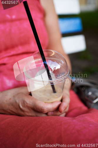 Image of Adult woman using smartphone on bench