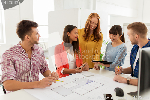 Image of creative team with blueprint working at office