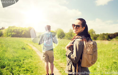 Image of happy couple with backpacks hiking outdoors